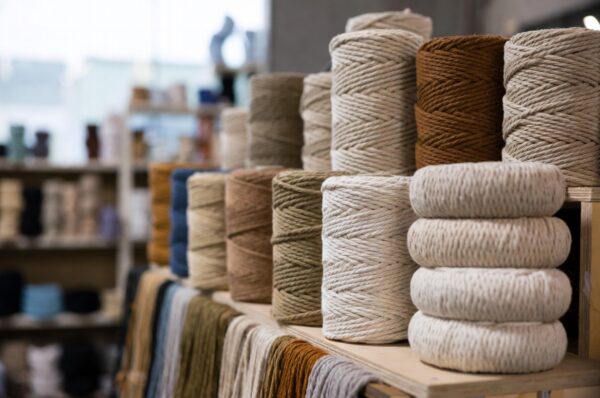 What Is Yarn Ply and Why It's Not the Same as Yarn Thickness When you step into the world of knitting, crocheting, or any yarn craft, you'll quickly encounter terms like "ply," "weight," and "thickness." For beginners and even some experienced crafters, these terms can be confusing. One of the most common misconceptions is that yarn ply and yarn thickness mean the same thing. However, this isn't true. Understanding the difference between yarn ply and yarn thickness is essential for choosing the right yarn for your project and achieving the results you envision. At Damodaram Enterprise, we pride ourselves on offering high-quality threads and yarns for all your crafting needs. Whether you're working on macrame projects, knitting delicate garments, or creating intricate crochet designs, understanding yarn characteristics helps you make informed decisions. In this comprehensive guide, we'll explain what yarn ply really means, how it differs from yarn thickness, and why this distinction matters for your crafting projects. Understanding Yarn Ply Yarn ply refers to the number of individual strands, or plies, that are twisted together to create a single strand of yarn. For example, if you take two single strands of fiber and twist them together, you create a 2-ply yarn. If you twist three strands together, you get a 3-ply yarn, and so on. The ply count tells you about the yarn's construction, not necessarily its thickness. A yarn can be labeled as 4-ply, but this simply means it's made from four twisted strands. It doesn't automatically tell you how thick or thin the yarn will be because the individual strands themselves can vary in thickness. Historically, ply was a more reliable indicator of yarn thickness, especially in traditional British and Australian yarn systems. However, with modern manufacturing techniques and the variety of fibers available today, this is no longer consistently true. Manufacturers can create thick 2-ply yarns or thin 4-ply yarns depending on how they spin the individual strands. Understanding Yarn Thickness and Weight Yarn thickness, often referred to as yarn weight, describes how thick or thin the actual yarn strand is. This is what determines how your finished project will look and feel. Yarn weight is typically categorized into standardized systems like the Craft Yarn Council's weight categories, which range from 0 (lace weight) to 7 (jumbo weight). When you look at yarn labels, you'll often see terms like fingering, sport, DK (double knitting), worsted, bulky, or super bulky. These terms describe the yarn's thickness and help you understand what size needles or hooks to use, what gauge to expect, and how the yarn will perform in your project. Unlike ply, yarn weight is a practical measurement that directly impacts your project. A bulky weight yarn will create a thick, warm fabric quickly, while a fingering weight yarn will produce delicate, lightweight fabric that takes more time to work up. At Damodaram Enterprise, we understand that choosing the right thickness is crucial for project success. That's why we offer detailed specifications for all our products, from our nylon macrame threads to specialized elastic threads for jewelry making. Why Yarn Ply and Thickness Are Not the Same The key difference between ply and thickness lies in what they measure. Ply measures the number of strands twisted together, while thickness measures the actual diameter of the finished yarn. Consider this example: You could have a 2-ply yarn made from thick individual strands that results in a bulky weight yarn. Conversely, you could have an 8-ply yarn made from very fine individual strands that results in a fingering weight yarn. The ply count alone doesn't tell you how the yarn will perform in your project. This confusion often arises because, in some traditional yarn systems, there was a correlation between ply and thickness. For instance, in historical British terminology, 4-ply yarn typically referred to what we now call fingering weight. However, this naming convention is no longer universal or reliable across all yarn brands and types. Modern yarn manufacturers focus more on yarn weight classifications because they provide crafters with more practical, consistent information. When you see a yarn labeled as worsted weight, you know immediately what needle size to use and approximately what gauge to expect, regardless of whether it's a 2-ply or 4-ply construction. How Ply Affects Yarn Performance While ply doesn't determine thickness, it does affect other important characteristics of yarn. Higher ply yarns tend to be more durable and have better stitch definition because the multiple strands twisted together create a rounder, more structured yarn. This makes them excellent for projects where you want your stitches to stand out clearly, such as in cable knitting or textured crochet patterns. Single-ply yarns, on the other hand, have only one strand and no twist structure. They can be softer and have more drape, making them ideal for projects where you want a fluid, flowing fabric. However, they may be less durable and more prone to pilling over time. For crafters working with materials from Damodaram Enterprise, understanding these characteristics helps in selecting the right thread for specific applications. Our range includes various constructions suitable for different project needs, from durable macrame cords to delicate jewelry threads. Practical Implications for Your Projects When selecting yarn for your project, focus primarily on the yarn weight or thickness rather than the ply count. Check your pattern requirements first. If a pattern calls for worsted weight yarn, you need to find yarn labeled as worsted weight, regardless of its ply construction. However, don't completely ignore ply information. If you're substituting yarns or designing your own patterns, understanding ply can help you predict how the yarn will behave. A higher ply yarn might give you better stitch definition for intricate colorwork, while a lower ply yarn might create a softer, more flowing fabric. Always check the recommended needle or hook size and gauge information on the yarn label. This practical information, combined with a gauge swatch, will ensure your project turns out with the correct dimensions and fabric characteristics. For specialized applications like macrame, thread thickness becomes even more critical. Our 1mm, 2mm, and 3mm macrame threads at Damodaram Enterprise are specifically sized to help you achieve the right look for your wall hangings, plant hangers, and other decorative projects. Understanding these measurements ensures your finished pieces have the structure and appearance you desire. Regional Differences in Yarn Terminology Adding to the confusion, different countries use different terminology for yarn weights. What Americans call sport weight, Australians might call 5-ply or 8-ply. What British crafters call DK (double knitting), Americans classify by its actual weight category. This is why the standardized yarn weight system developed by the Craft Yarn Council has become so valuable. It provides a universal language that transcends regional variations and focuses on the practical aspects crafters need to know. When working with international patterns or yarn brands, always check the recommended gauge and needle size rather than relying solely on the yarn name or ply count. This approach will save you from potential sizing disasters and ensure your project success. Choosing the Right Yarn from Damodaram Enterprise At Damodaram Enterprise, we believe in empowering crafters with the knowledge and materials they need for successful projects. Whether you're exploring our extensive collection of nylon macrame threads, elastic threads for jewelry making, or specialized craft supplies, understanding the difference between ply and thickness helps you make the best choice. Our product range is designed with clarity in mind. We provide specific measurements for thread diameters, helping you select exactly what you need without confusion. From our popular 3mm macrame threads to our fine 0.8mm elastic threads, each product is clearly labeled with the information that matters most for your projects. We encourage you to explore our blog for more helpful guides, including articles on how to choose the right yarn for your crochet and knitting projects, how to read yarn labels, and understanding the differences between natural and synthetic yarns. These resources complement our product offerings and help you become a more informed, confident crafter. Conclusion Understanding that yarn ply and yarn thickness are not the same thing is fundamental to becoming a skilled crafter. Ply tells you about the yarn's construction—how many strands are twisted together—while thickness or weight tells you about the yarn's practical characteristics—how it will perform in your project. Focus on yarn weight when selecting materials for your projects, but don't ignore ply information entirely, as it provides insights into the yarn's durability and stitch definition. Most importantly, always make a gauge swatch before starting any significant project to ensure your chosen yarn will produce the results you want. At Damodaram Enterprise, we're committed to supporting your creative journey with high-quality threads, comprehensive product information, and educational resources. Whether you're a beginner just learning the basics or an experienced crafter perfecting your technique, understanding these fundamental concepts will enhance your crafting experience and help you create beautiful, successful projects. Visit our collection today to explore our full range of threads and yarns, and don't hesitate to reach out if you need guidance in selecting the perfect materials for your next creative endeavor.